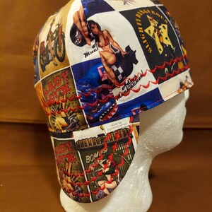 May include: A patchwork welding cap featuring vintage-style pin-up girl and motorcycle graphics in a collage design. The cap has a red embroidered trim and a white interior. The cap is designed to protect the wearer from sparks and heat.