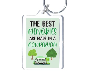 May include: A white and green acrylic keychain with the text "THE BEST MEMORIES ARE MADE IN A CAMPERVAN" and a cartoon image of a camper van driving through a forest.