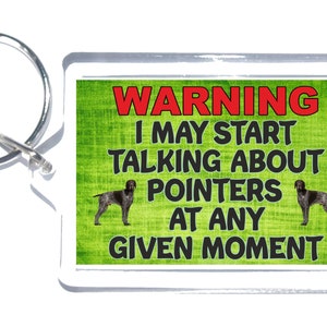 May include: A green and white warning sign with a black and brown dog on each side. The sign reads "WARNING I MAY START TALKING ABOUT POINTERS AT ANY GIVEN MOMENT".