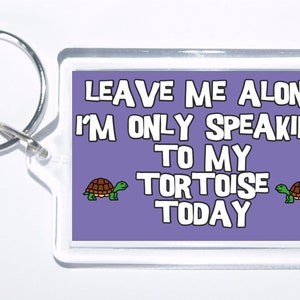 May include: Purple keychain with the text "Leave me alone I'm only speaking to my tortoise today" and two cartoon tortoises on either side of the text.