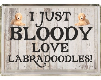 Könnte beinhalten: Ein weißer Holzgrund mit einem schwarzen Textüberlagerung, der "Ich liebe Labradoodle einfach!" lautet. Zwei Labradoodle-Hunde sind auf beiden Seiten des Textes abgebildet.