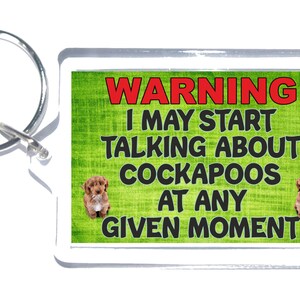May include: A green and white warning sign with a brown dog on each side. The sign reads "WARNING I MAY START TALKING ABOUT COCKAPOOS AT ANY GIVEN MOMENT".