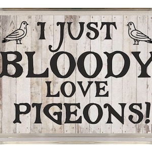 May include: A white wooden sign with black text that reads "I just bloody love pigeons!" with a black silhouette of a pigeon on each side of the text.
