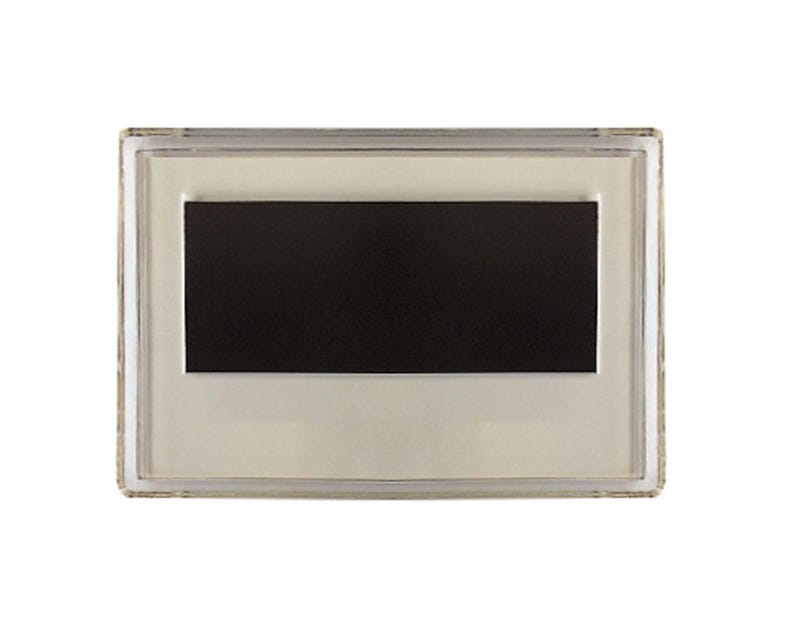 May include: A clear plastic frame with a black magnetic surface inside. The frame is designed to hold a photo or other small item.
