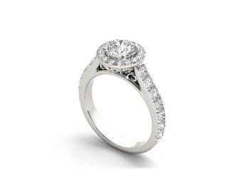 Può includere: Un anello di fidanzamento in argento con un diamante centrale rotondo circondato da un alone di diamanti più piccoli. La fascia è anche incastonata con diamanti più piccoli.