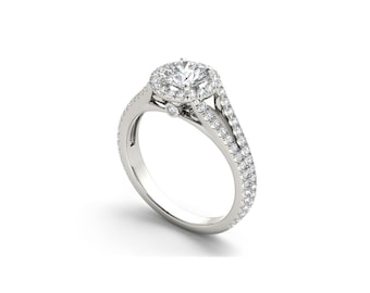 Può includere: Un anello di fidanzamento in argento con una pietra centrale rotonda circondata da un alone di pietre più piccole. La fascia è divisa e presenta una fila di pietre più piccole su ogni lato.