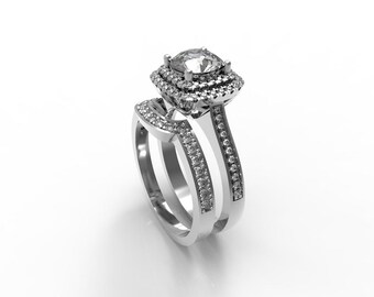 Può includere: Un anello di fidanzamento in argento con un grande diamante a cuscino circondato da diamanti più piccoli. La fascia è anche incastonata con diamanti più piccoli.