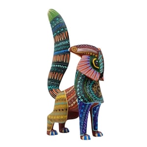 May include: A vibrantly painted wooden sculpture of a stylized animal with a long, curved tail. The sculpture features intricate patterns and a color palette of green, orange, blue, and brown. The artwork is a decorative piece.