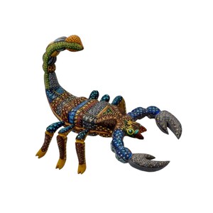 May include: A colorful wooden scorpion sculpture with intricate geometric patterns in shades of blue, green, brown, and yellow. The scorpion's tail is curled up, and its claws are extended.