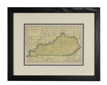 May include: Framed vintage map of Kentucky, featuring a detailed depiction of the state's roads and cities. The map is in shades of yellow and green, set against a cream-colored mat and a black wooden frame.