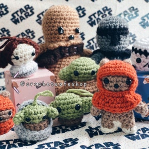 Op de afbeelding: Een verzameling van gehaakte Star Wars-personages, waaronder Yoda, Chewbacca, een Stormtrooper en een Mandalorian. De personages zijn allemaal handgemaakt en hebben verschillende kleuren en texturen.