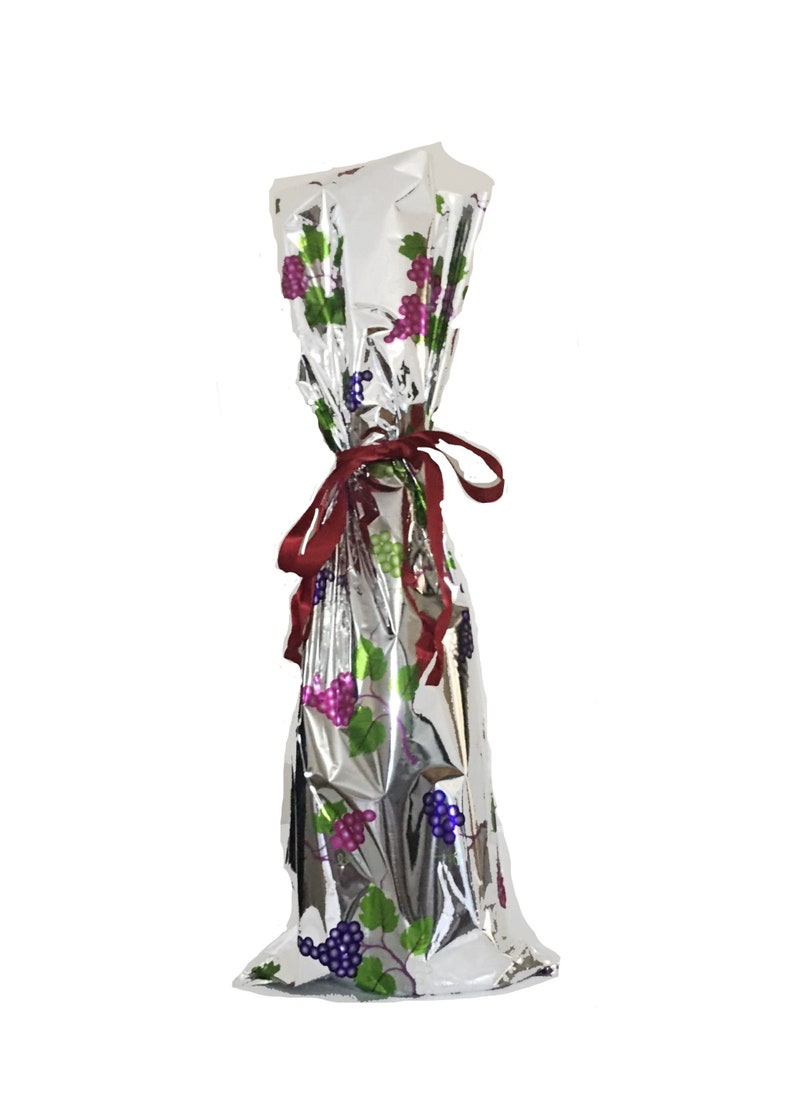 Puede incluir: Una bolsa de botella de vino de papel de aluminio plateado con una cinta roja y un patr&oacute;n de vid. La bolsa est&aacute; dise&ntilde;ada para contener una botella de vino de tama&ntilde;o est&aacute;ndar.