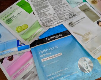 May include: A selection of face masks, including a blue Neutrogena Hydro Boost Hydrating 100% Hydrogel Mask with the text "instantly quenches skin deeply hydrates skin supple and hydrated", a pink Dermal Cucumber Collagen Essence Mask with the text "Cucumber Collagen Essence Mask キュウリコラーゲンエッセンスマスク", a white Dermal Milk Collagen Essence Mask with the text "Milk Collagen Essence Mask 牛乳コラーゲンエッセンスマスク", and a white Snail Collagen Mask with the text "Snail Collagen コラーゲン".