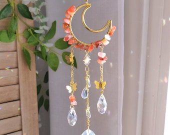 May include: A gold metal crescent moon wind chime with carnelian stones and crystal drops. The chime features a star charm and butterfly charms.