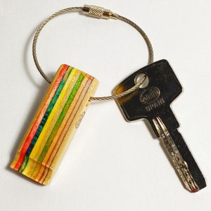 Handmade keychains made from recycled skateboard decks, a thin layer of clear resin, and finished with a steel hook.