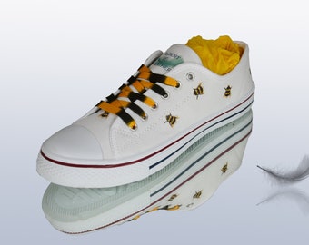 Bee decorated low top sneakers with bee laces.