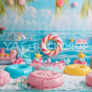 Puede incluir: Un telón de fondo con temática de verano con una toalla de playa a rayas azules y blancas, toallas de playa a rayas rosas y blancas y una sombrilla de playa a rayas rosas y blancas. También hay varios flotadores de piscina inflables de varios colores y diseños.