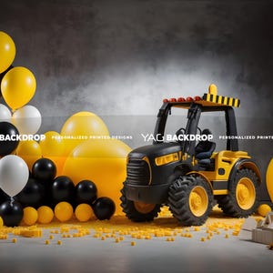 Puede incluir: Un vehículo de construcción de juguete negro y amarillo con un globo amarillo y globos negros y amarillos en el fondo.