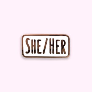 She/Her pronoun enamel pin badge on pink background