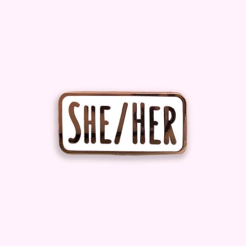 She/Her pronoun enamel pin badge on pink background