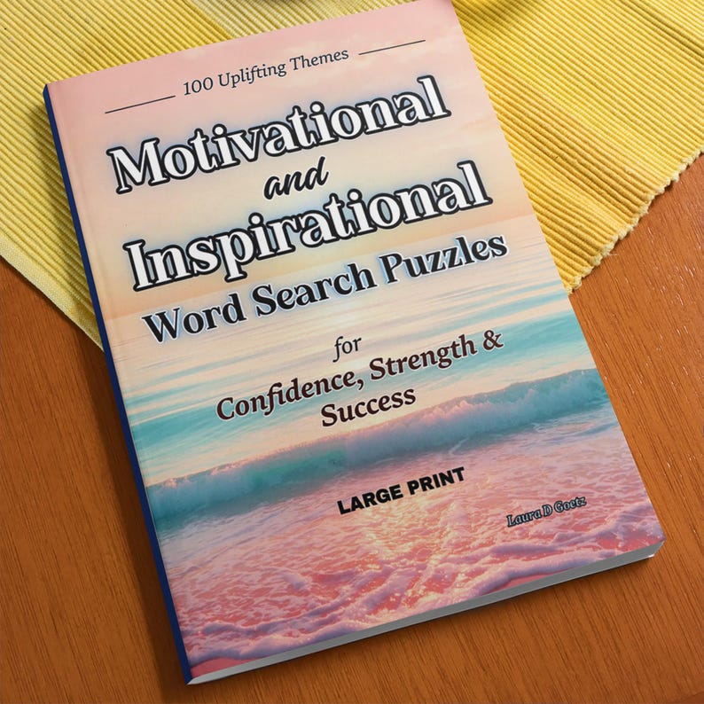 Może przedstawiać: Książka z dużą czcionką zatytułowana "Motivational and Inspirational Word Search Puzzles" z tłem sceny na plaży. Okładka książki zawiera tekst "for Confidence, Strength & Success" i "100 Uplifting Themes".