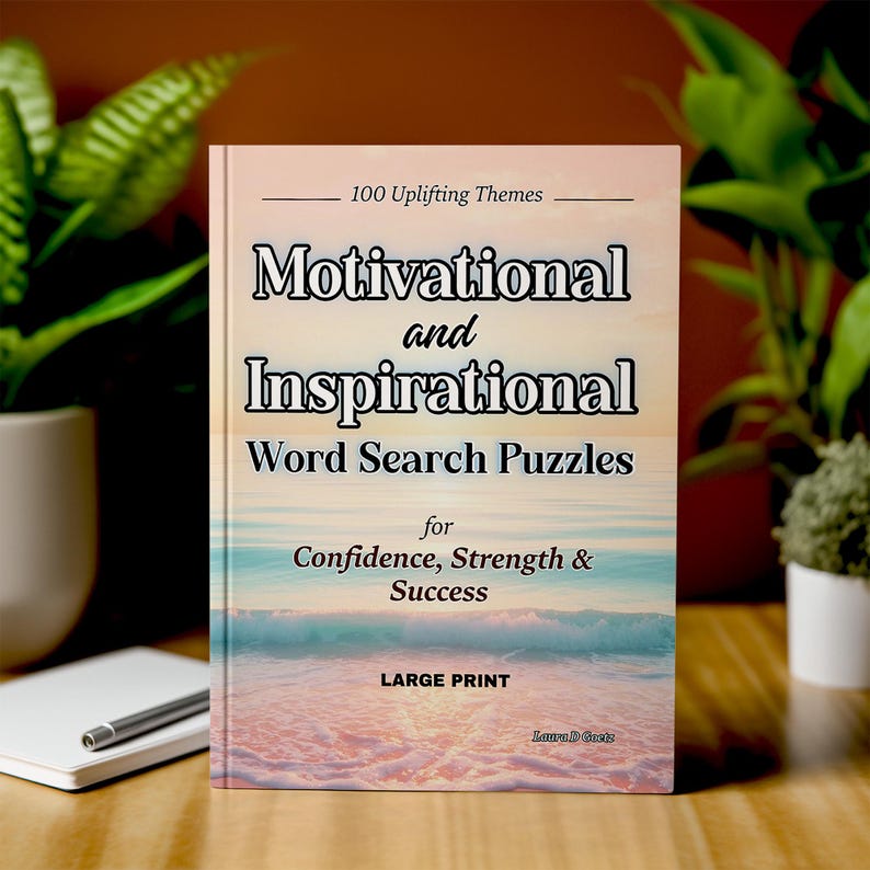 Może przedstawiać: Książka zatytułowana "Motivational and Inspirational Word Search Puzzles" z tekstem "100 Uplifting Themes" i "for Confidence, Strength & Success". Okładka przedstawia scenę na plaży z dużym nadrukiem. Notatnik i długopis znajdują się na pierwszym planie.