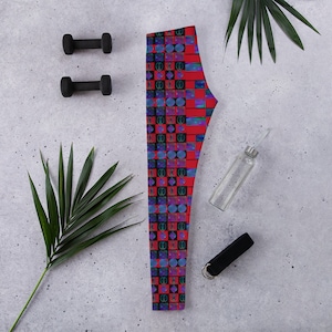 May include: Red leggings with a geometric pattern of blue, black, and white squares and circles.