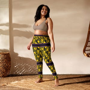 May include: Yellow and black patterned leggings with a geometric design. The leggings feature a repeating pattern of yellow diamonds outlined in black, with purple and black bands at the waist and ankles. The leggings are made of a soft, comfortable material.