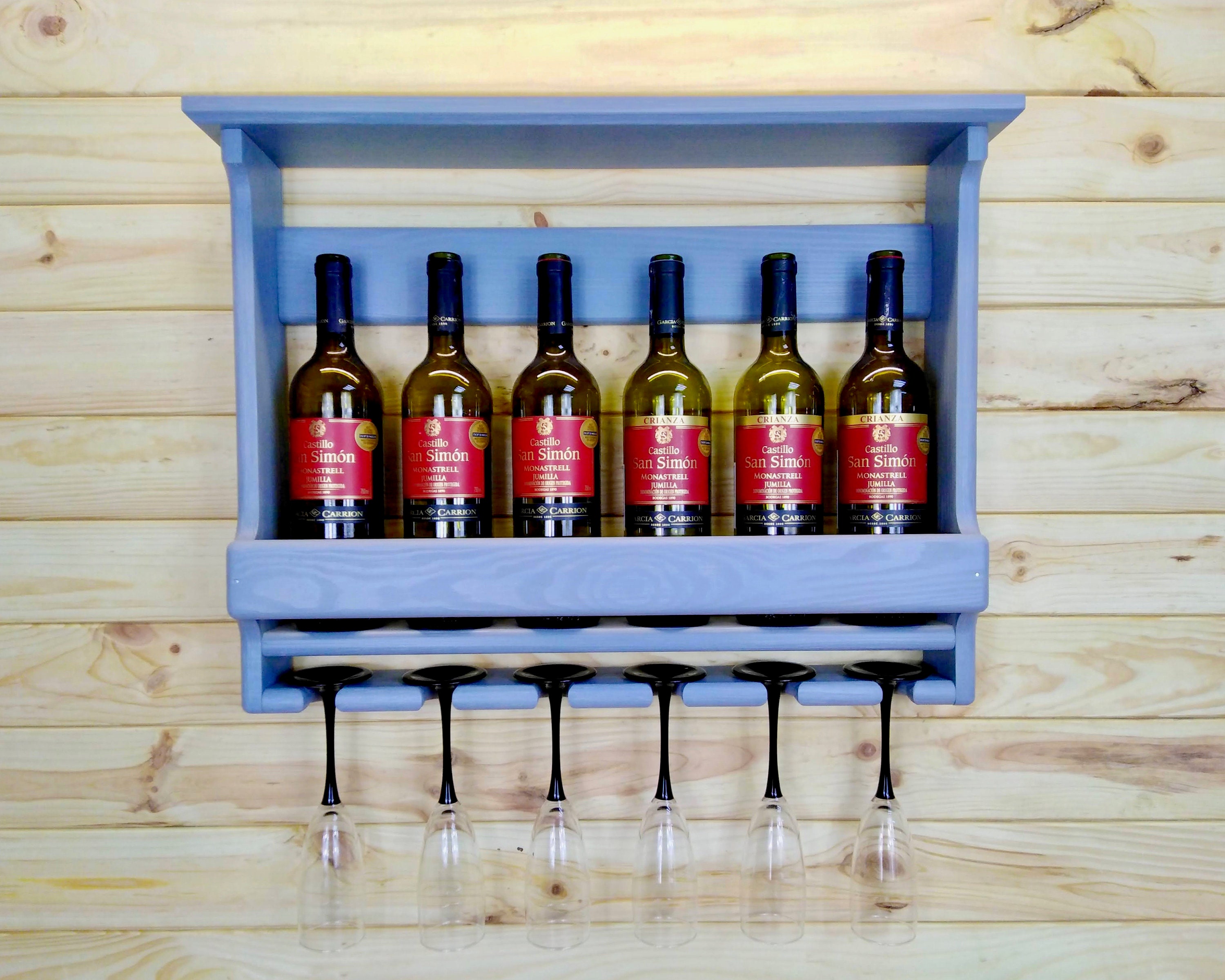 Bar de vinos con una elegante barra de bar, taburetes de bar y estantes  retroiluminados que exhiben botellas