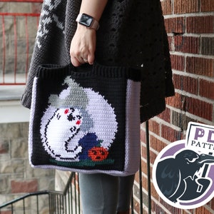 May include: A crocheted tote bag with a black background and a white ghost holding a pumpkin. The bag has a purple, green, and gray design. The text "PDF PATTERN" is on a sign held by a black crow.