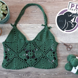 May include: A handmade green crochet bag with a geometric pattern and braided straps. The bag is displayed on a wooden surface with a small succulent plant, scissors, and green yarn. A PDF pattern logo is visible.