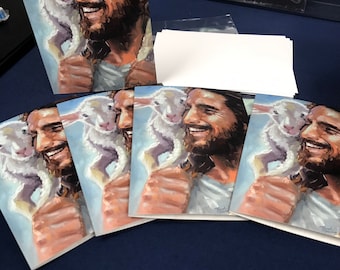 May include: Five cards with a painting of a man with a lamb on his shoulder. The man has a beard and is smiling. The lamb is white and has a black nose. The background is a light blue sky.