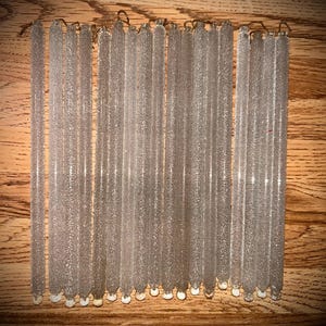 May include: A collection of 20 clear glass icicle ornaments with a frosted finish. The icicles are approximately 10 inches long and have a white tip.