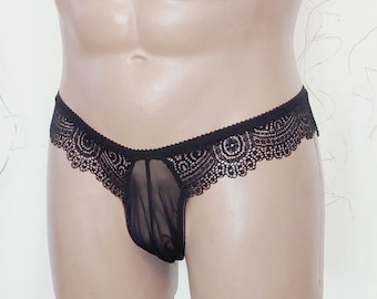 May include: Black lace underwear with a sheer mesh panel. The lace has a delicate floral pattern.