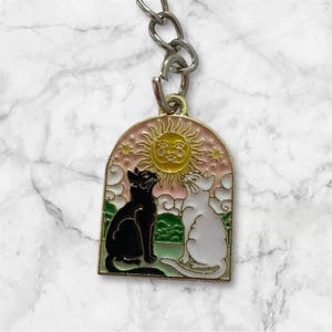 Porte-clés fantaisie en métal et émail avec mini chats noirs et blancs soleil