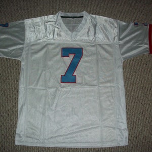 Puede incluir: Camiseta de f&uacute;tbol blanca con el n&uacute;mero 7 azul y rayas rojas y azules en las mangas.