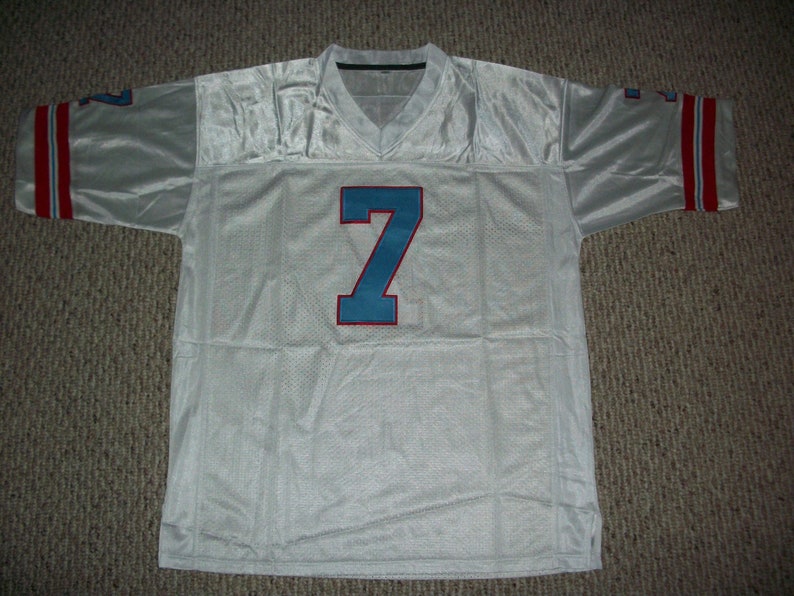 Puede incluir: Camiseta de f&uacute;tbol blanca con el n&uacute;mero 7 azul y rayas rojas y azules en las mangas.