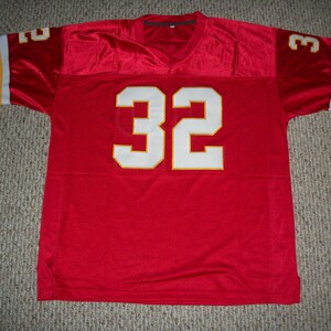 Puede incluir: Camiseta de f&uacute;tbol roja con el n&uacute;mero 32 blanco en la parte delantera. La camiseta tiene rayas amarillas y blancas en las mangas.