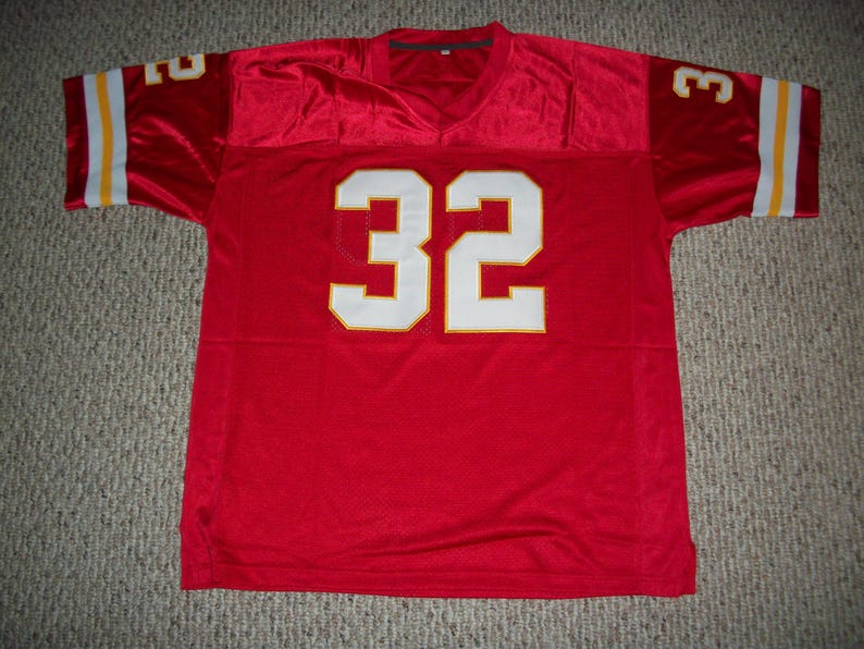 Puede incluir: Camiseta de f&uacute;tbol roja con el n&uacute;mero 32 blanco en la parte delantera. La camiseta tiene rayas amarillas y blancas en las mangas.