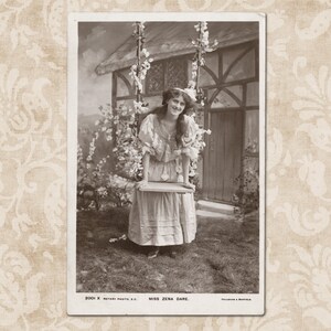 L'actrice Zena Dare s'appuyant sur une balançoire avec des guirlandes de fleurs - Carte postale édouardienne vintage originale du début des années 1900.
