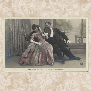 Puede incluir: Postal vintage con un hombre y una mujer en traje formal. La mujer lleva un vestido rosa y sostiene un abanico, mientras que el hombre besa su sombrero. La postal tiene el texto "Seduction! - I. - Oh! Mopsieur..."