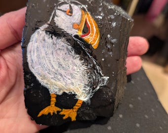 Roccia raffigurante una pulcinella di mare dipinta a mano.