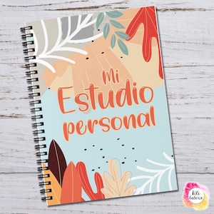 May include: A spiral-bound notebook with a light blue cover featuring abstract leaf illustrations in red, orange, and white. The text "Mi Estudio personal" is printed in orange in the center. Small black dots are scattered across the cover design.