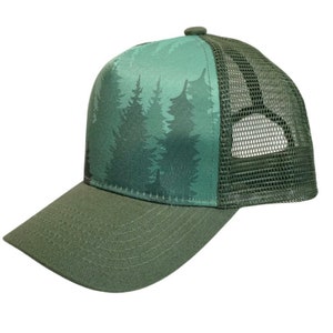 May include: A green trucker hat with a forest silhouette print on the front. The hat has a mesh back and a curved brim.