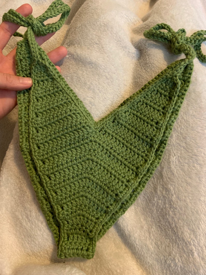 Puede incluir: Un top de bikini de crochet verde con tirantes ajustables. El top est&aacute; hecho con un patr&oacute;n de punto simple y tiene un escote en V.