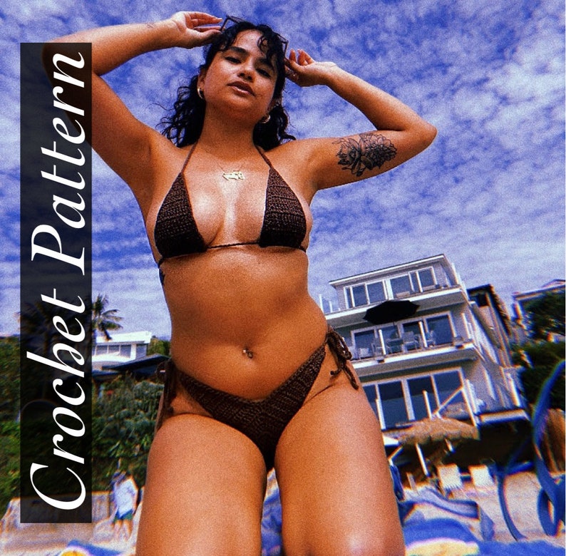 Puede incluir: Un top y una parte inferior de bikini de crochet marr&oacute;n con tirantes finos. El bikini lo lleva una persona con un tatuaje en el brazo. La persona est&aacute; de pie en una playa con un cielo azul y nubes blancas de fondo.