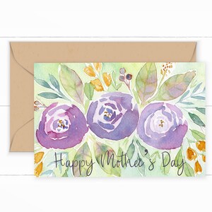 Pode incluir: Um cart&atilde;o de felicita&ccedil;&otilde;es em aquarela com um design floral. O cart&atilde;o apresenta flores roxas, folhas verdes e detalhes amarelos. O texto "Happy Mother's Day" est&aacute; escrito em caligrafia preta.