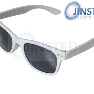 Puede incluir: Gafas de sol blancas con lentes oscuras. Las monturas son de un blanco brillante y las patillas grises claras. Las gafas tienen un diseño clásico y retro, adecuadas para días soleados.