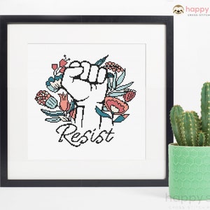 May include: A cross-stitch pattern featuring a raised fist surrounded by colourful flowers with the word "Resist" written below.