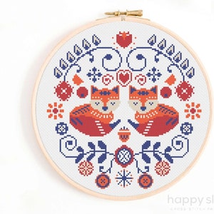 a cross stitch picture of two foxes in a circle